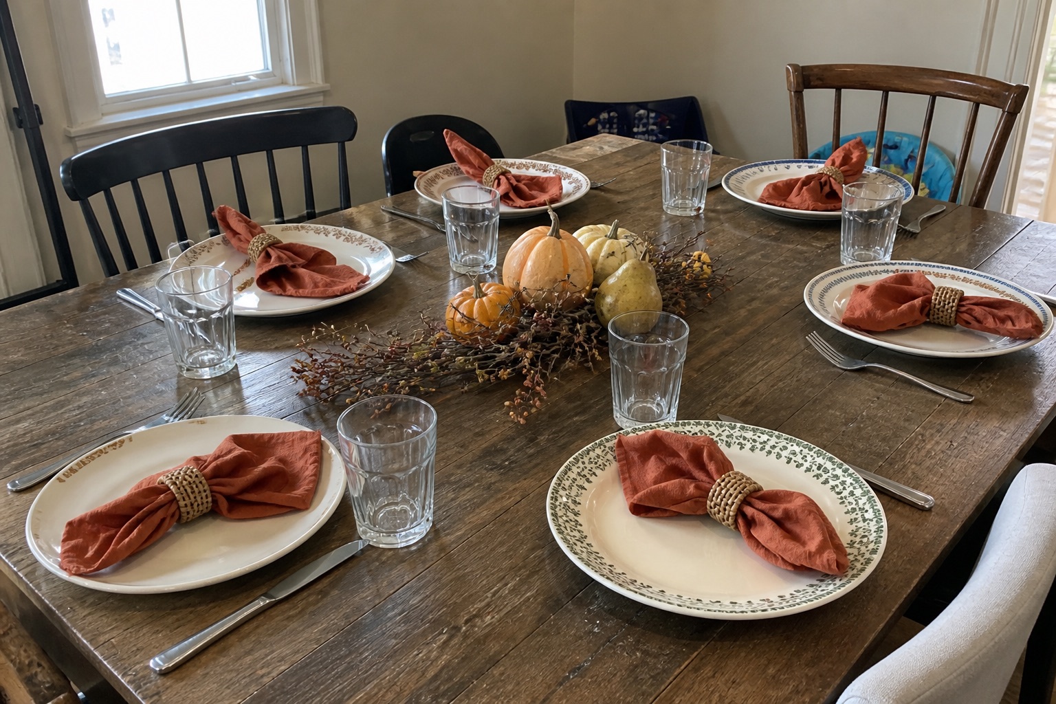A practical Thanksgiving dining table with rust linen, pears, short candles and room for serving dishes